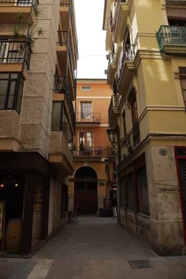 Narrow alleyway with residential buildings and hanging laundry.
