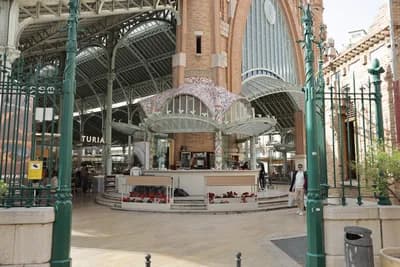 Interior of a grand market with arched ceilings and decorative elements.