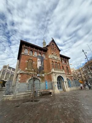 Historic building with intricate details and a cloudy sky in the background.