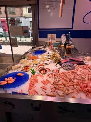 Exposition de fruits de mer avec des crevettes et d'autres fruits de mer sur glace dans un stand de marché.