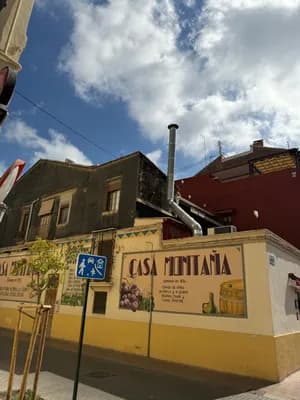 A wall with a sign reading 'Casa Montañía' and a pedestrian crossing sign in front of a building under a partly cloudy sky.