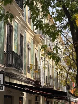 A row of colorful buildings with balconies and tiled facades in a sunny urban setting.