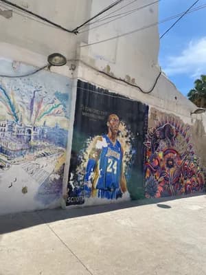 A vibrant mural with a basketball player and other artistic details on a city wall.