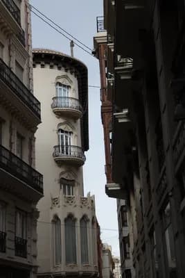 Narrow street with ornate buildings and balconies.