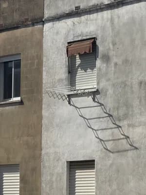 Shadow of a ladder on a building wall