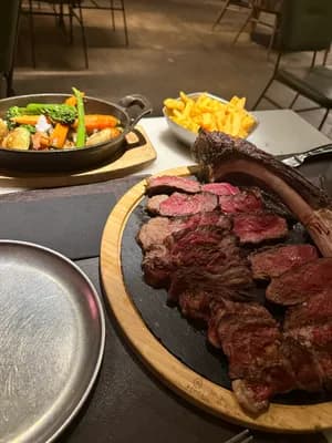 A meal with a steak, fries, and vegetable medley on a table.