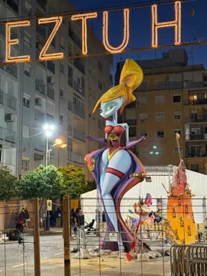 A vibrant, animated figure under a neon sign in an urban environment at night.