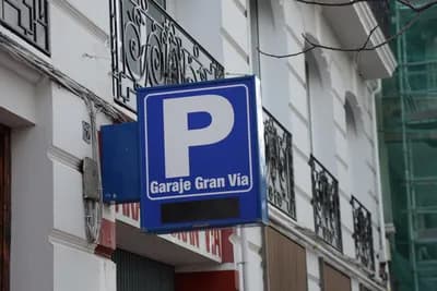 Parking sign for Garaje Gran Via on a building facade.