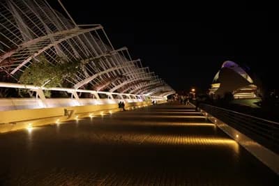 Modern architecture at night with illuminated pathways and structures.