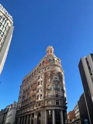 Tall ornate building with spire against clear blue sky.