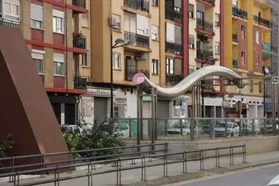 Modern urban architecture with a curved structure and residential buildings.