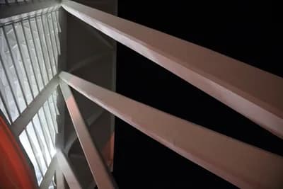 Close-up of a metal railing with a dark background.