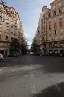 Quiet street with residential buildings and a marked crosswalk.