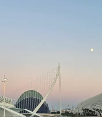 Modern architecture with a cable-stayed bridge at dusk.
