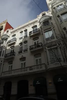 A close-up of an elegant building with intricate balconies and architectural details.