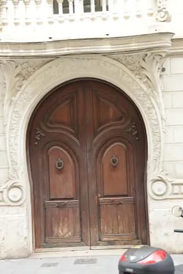 An intricately carved wooden door with a small balcony above it.