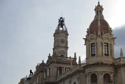 Historic building with ornate architecture, clock tower, and red-tiled dome.