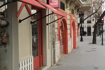 Row of shops with red awnings and doors in Valencia, Spain.