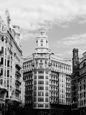 Tall, ornate black and white building with curved facade and multiple windows.
