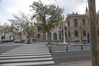 A street with a pedestrian crossing and historic buildings in the background.