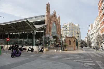 A street view with a covered market and urban buildings.