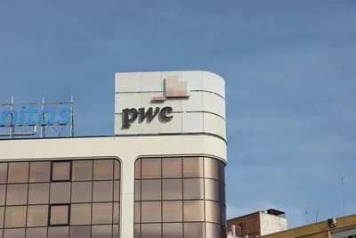 Modern building with PwC and Unitas signage against blue sky.