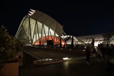 Modern architecture at night with people walking.