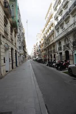 A street scene with tall buildings and parked motorcycles.