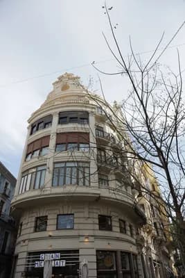 A curved, ornate building with a decorative top and multiple windows.