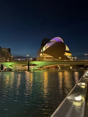 Modern architecture reflected in water at night.