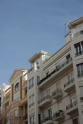 Residential buildings with balconies and a clear blue sky.