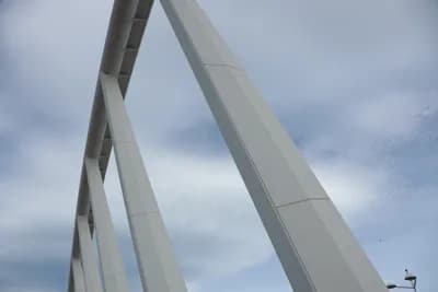 Close-up of a white modern structure against a cloudy sky.