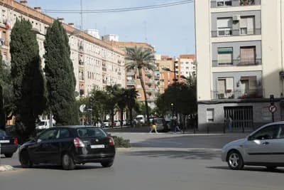 Urban street with cars and pedestrians in Valencia, Spain.