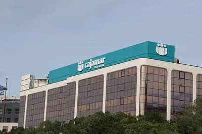 Modern teal building with 'cajamar' logo and white emblem.