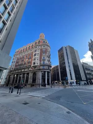 Historic building with ornate architecture in an urban setting under a clear blue sky.