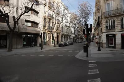 A street corner with buildings, trees, and a traffic light.
