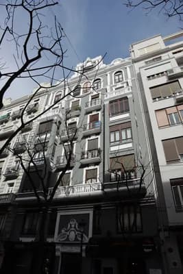 A multi-story building with balconies and a clear sky.