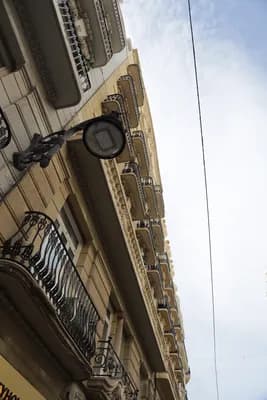 Streetlamp on ornate building with balconies and cloudy sky