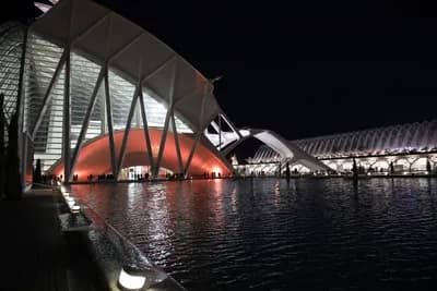 Modern architecture reflected in water at night.