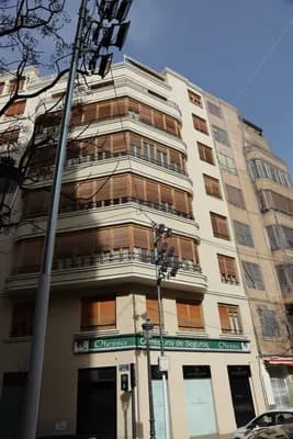 Modernist building with curved balconies and a street sign.