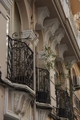 Close-up of ornate balconies with wrought iron railings and decorative architectural details.
