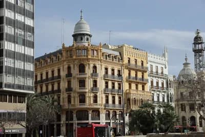 Historic building with ornate balconies and dome in urban setting.