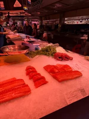 Poisson frais sur glace à un stand de marché avec des herbes et du poulpe.