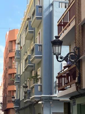 Colorful residential buildings with balconies and a decorative street lamp.
