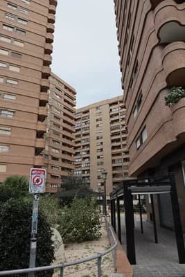 Tall residential buildings with a pedestrian walkway and greenery.