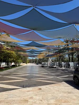 Street with colorful fabric canopies providing shade.