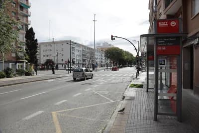 Stadtbild mit Bushaltestelle und Taube auf dem Bürgersteig.