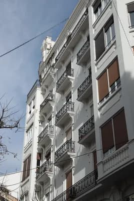 A multi-story building with balconies and a clear sky.