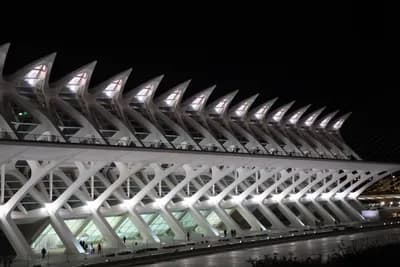 A futuristic building with illuminated, pointed sections at night.